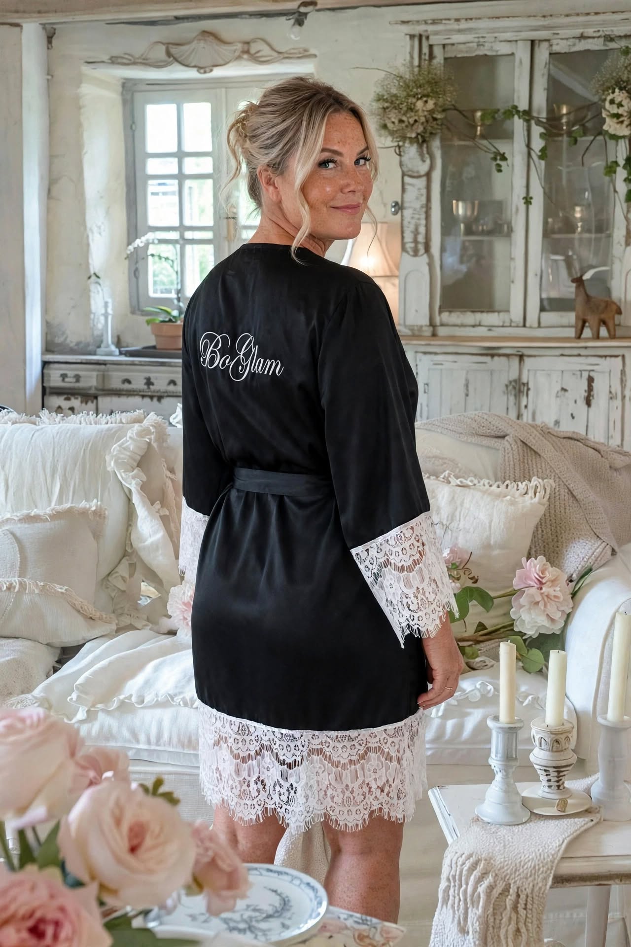 Woman wearing the black satin BO-GLAM robe, showing the BoGlam embroidery on the back