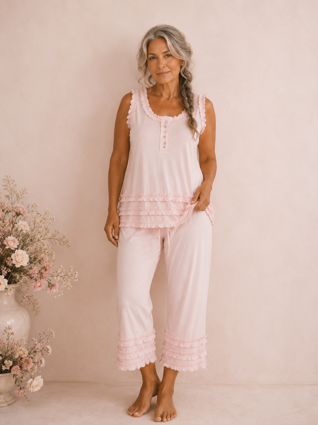 Model wearing pink ruffled Heaven Sent Pretty cotton pyjamas beside a vase of roses